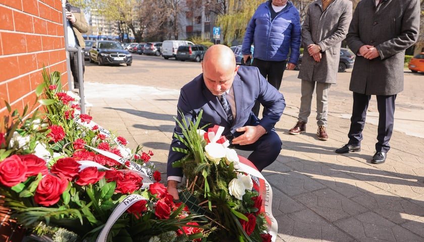 Składanie kwiat&oacute;w pod tablicą Jerzego Szmajdzińskiego