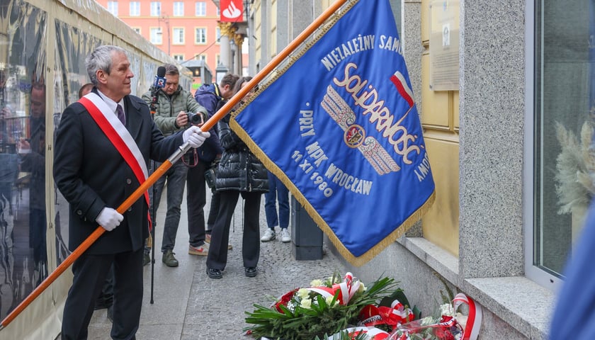 Składanie kwiat&oacute;w pod tablicą Aleksandry Natalii-Świat