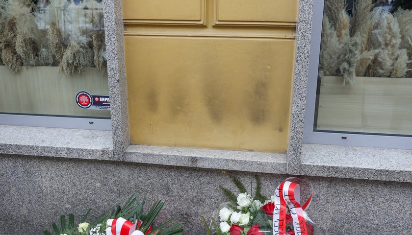 Składanie kwiat&oacute;w pod tablicą Aleksandry Natalii-Świat