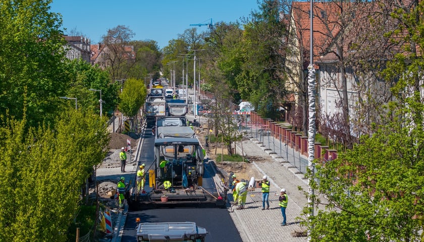 Powiększ obraz: Układanie ostatniej warstwy masy bitumicznej na ulicy Koszarowej. Zdjęcie z 29 kwietnia