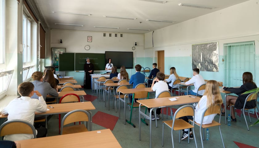 Powiększ obraz: Uczniowie piszący w klasie egzamin ósmoklasisty - zdjęcie archiwalne