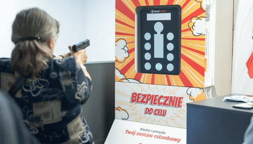 Powiększ obraz: Zdjęcie przedstawia osobę, która mierzy do laserowej „Strzelnicy Bezpieczny Wrocław”, która jest jedną z atrakcji podczas Wakacji z wroclaw.pl