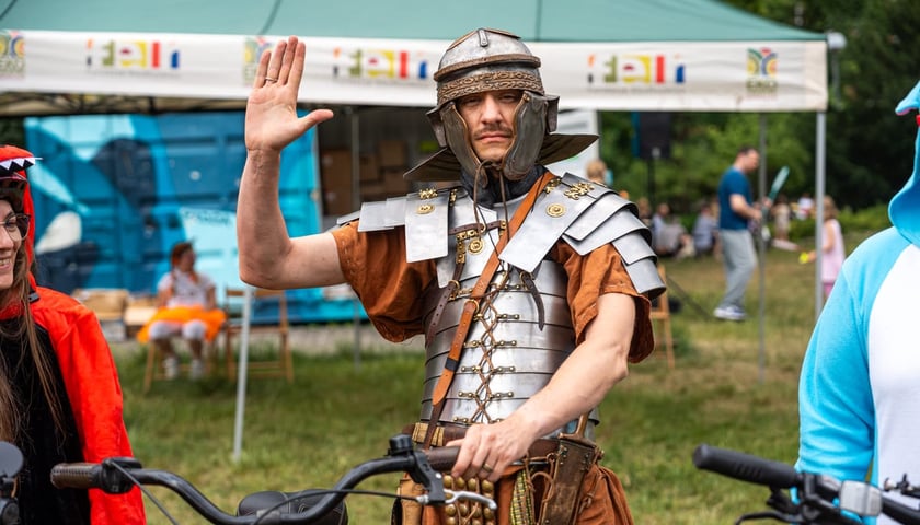 Powiększ obraz: <p>Rowerzysta w zbroi rzymskiego legionisty. Rowerowy piknik w Parku Tołpy. Zdjęcie archiwalne, wykonane 10 czerwca 2024.</p>