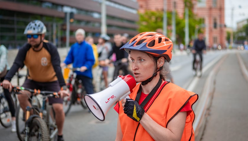 Powiększ obraz: <p>Wolontariuszka i rowerzyści jadący w peletonie przez Wrocław. Wrocławskie Święto Rowerzysty. Zdjęcie archiwalne z 8 czerwca 2025.</p>