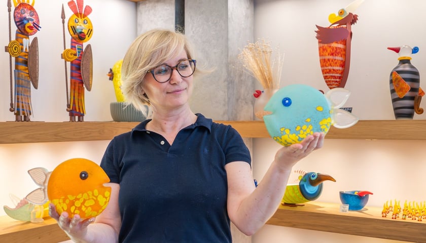Powiększ obraz: Katarzyna Borowski trzyma w dłoniach kolorowe szklane rzeźby