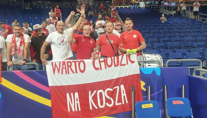 Powiększ obraz: Kibice reprezentacji Polski, wśród nich Szoku podczas Eurobasketu 2022, z flagą - Warto chodzić na kosza