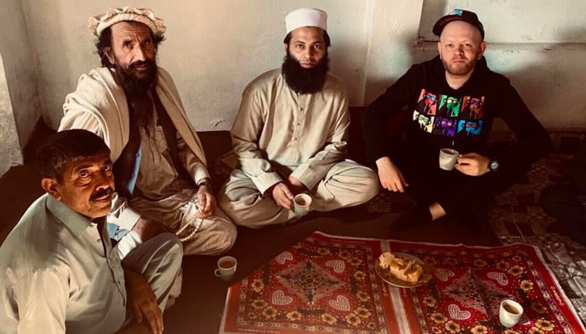 Powiększ obraz: Na zdjęciu Andrzej Gliniak siedzi na dywanie i pije herbatę w towarzystwie Pakistańczyków w Peszawarze, jednym z najniebezpieczniejszych miast Pakistanu, tuż przy granicy z Afganistanem. Siedzący najbliżej mężczyzna ma ksywkę ?Talib?.