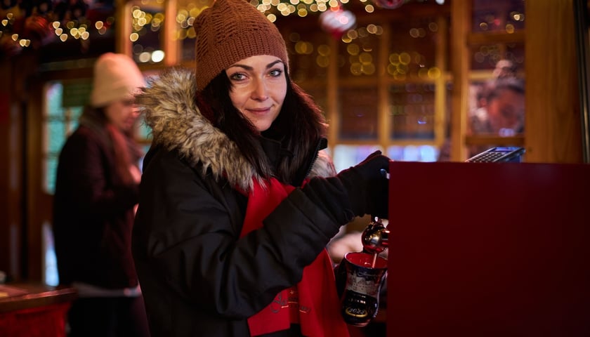 Powiększ obraz: Na zdjęciu sprzedawczyni nalewająca grzańca na Jarmarku Bożonarodzeniowym 2022 we Wrocławiu