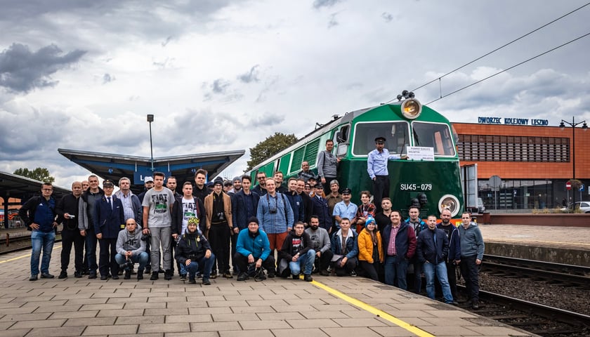 Powiększ obraz: Na zdjęciu widać uczestników podróży zabytkowym pociągiem w 2022 roku. W tle pociąg retro z lokomotywą "fiat"