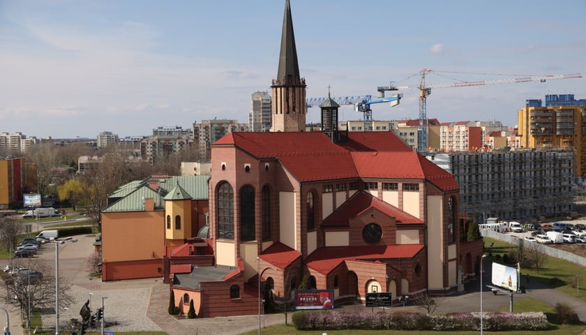 Powiększ obraz: <p>Kości&oacute;ł pw. św. Maksymiliana Marii Kolbego, na dole po lewej pomnik Jana Pawła II&nbsp;</p>