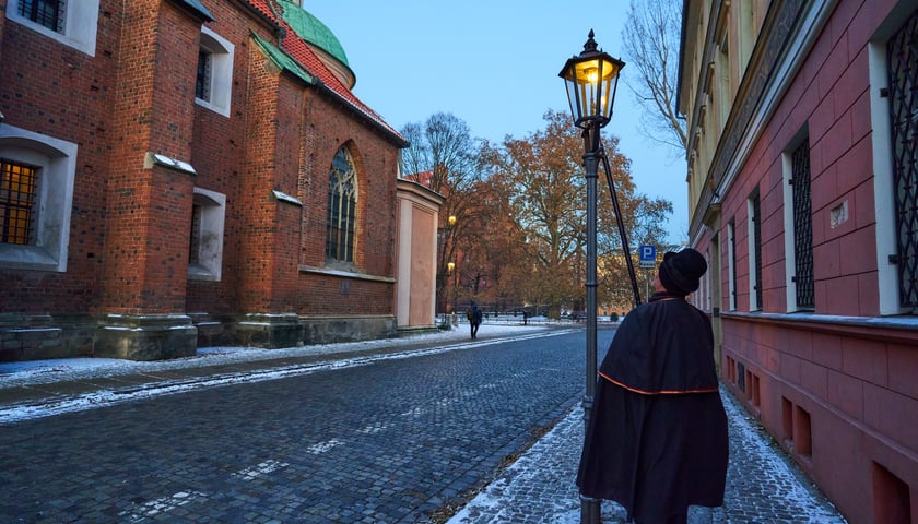 Powiększ obraz: Latarnik każdego wieczora we Wrocławiu zapala na Ostrowie Tumskim latarnie.