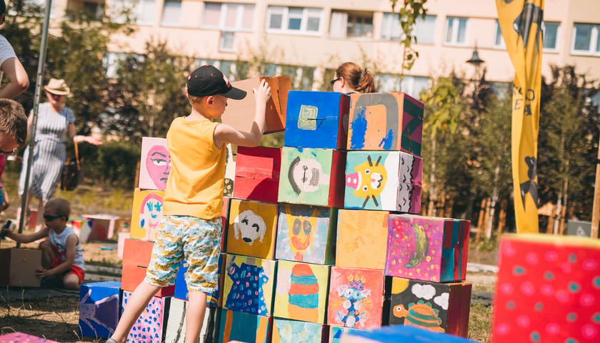 Powiększ obraz: Chłopiec ustawiający mur z wielkich kolorowych klocków, Cyrkopole 2022