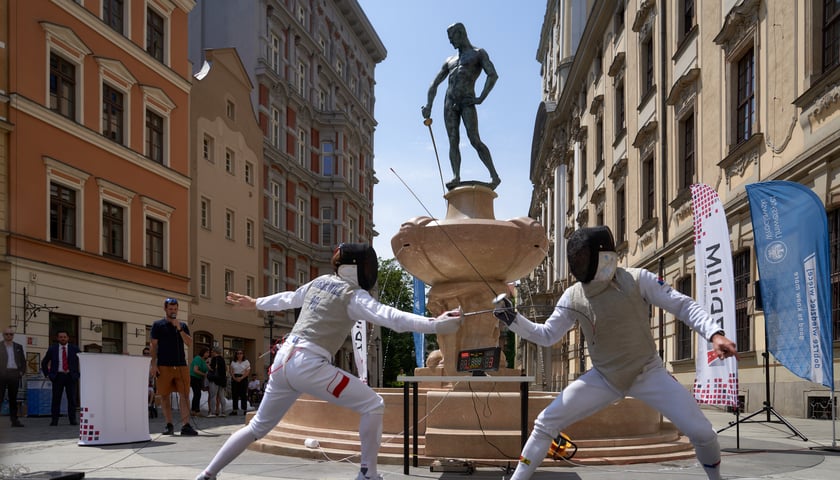 Powiększ obraz: Szermierze walczący na tle fontanny z Szermierzem podczas otwarcia po remoncie