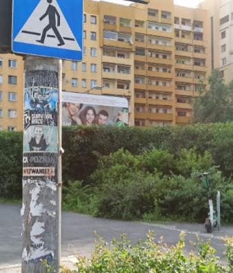 Nielegalnie umieszczone plakaty na miejskiej latarni