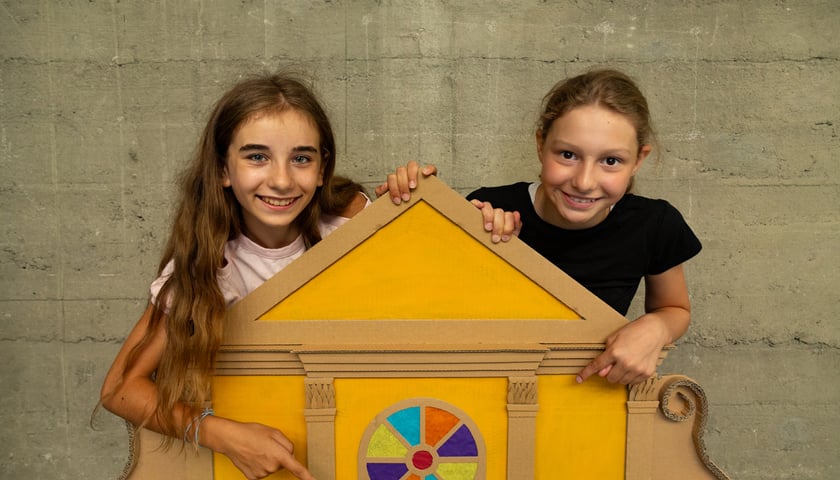 Powiększ obraz: Dwie dziewczynki z makietą budynku wykonaną z tektury