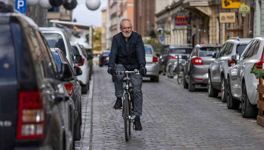 Powiększ obraz: Cezary Grochowski, prezes Wrocławskiej Inicjatywy Rowerowej jedzie rowerem przez ul. Rzeźniczą
