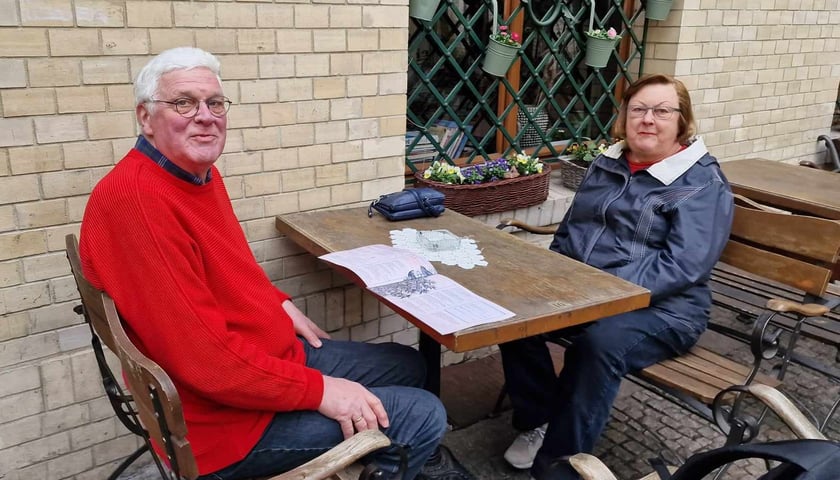 Powiększ obraz: <p>Ogr&oacute;dki gastronomiczne na Starym Mieście we Wrocławiu w marcu 2024</p> Na zdjęciu dwie osoby: pan w czerwonym swetrze siedzi przy stoliku z panią
