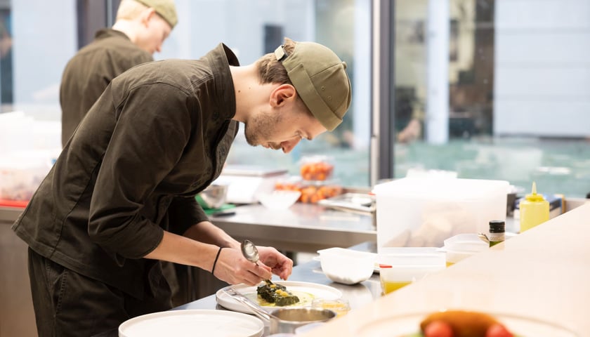 Powiększ obraz: Kucharz przygotowuje potrawę w restauracji Nai przy pl. Jana Pawła II