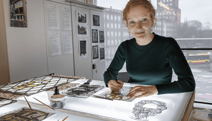 Powiększ obraz: Karolina Dyduch, studentka Pracowni Konserwacji i Restauracji Witraży na wrocławskiej Akademii Sztuk Pięknych przy stole roboczym