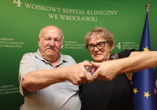 Powiększ obraz: Danuta i Henryk Łukasiewiczowie, oboje po udanej operacji wady serca, łączą dłonie w jego kształt