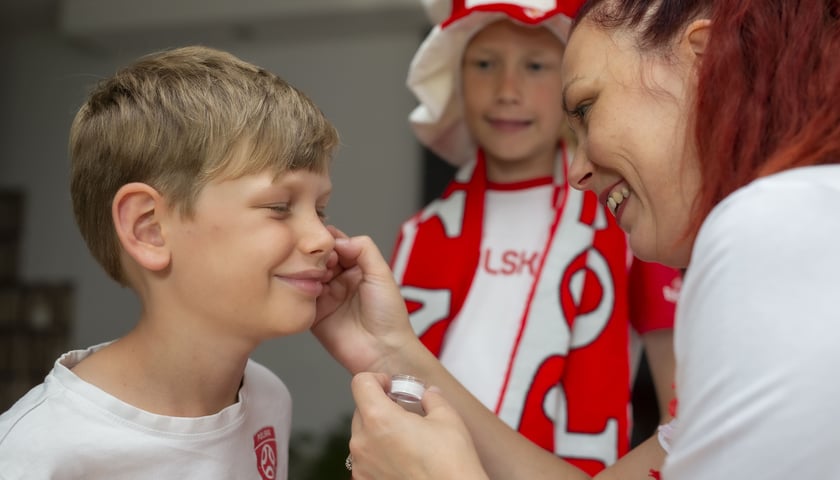 Powiększ obraz: Kibice malujący twarze w barwy Polski