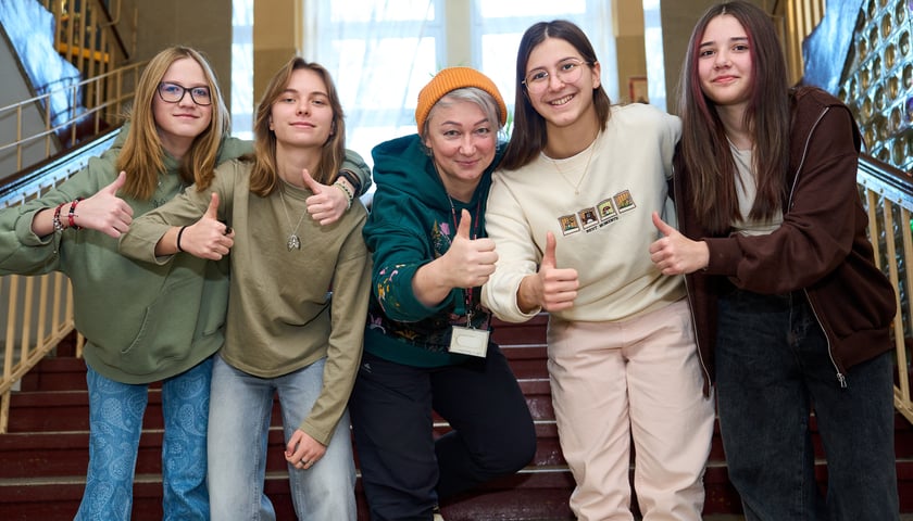 Powiększ obraz: Cztery uczennice XII LO i nauczycielka Edyta Morska (w środku w czapce ) na schodach w szkole
