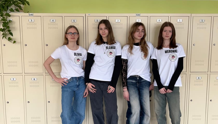 Powiększ obraz: Cztery nastolatki ubrane w białe koszulki z logo akcji „Mniej zmęczony - lepiej wyuczony"