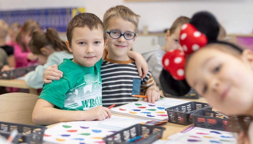 Powiększ obraz: Dwóch chłopców pozuje do zdjęcia na zajęciach plastycznych w Zespole Szkolno-Przedszkolnym nr 26 przy ul. Cynamonowej