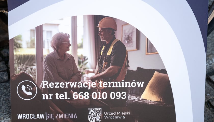 Powiększ obraz: Starsza kobieta rozmawia z fachowcem – napis Bezpłatna Wrocławska Złota Rączka dla Seniora