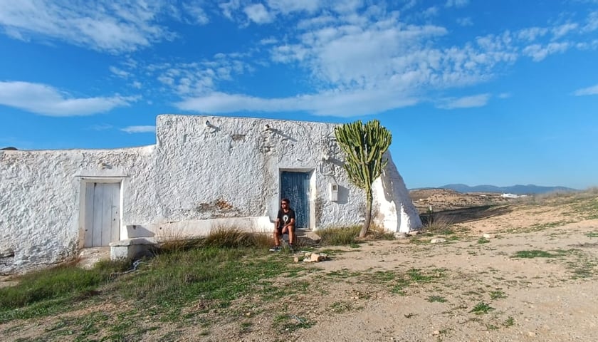 Powiększ obraz: Klasyczny biały dom na andaluzyjskiej wsi. Obok niego rośnie kaktus. W tle niebieskie niebo