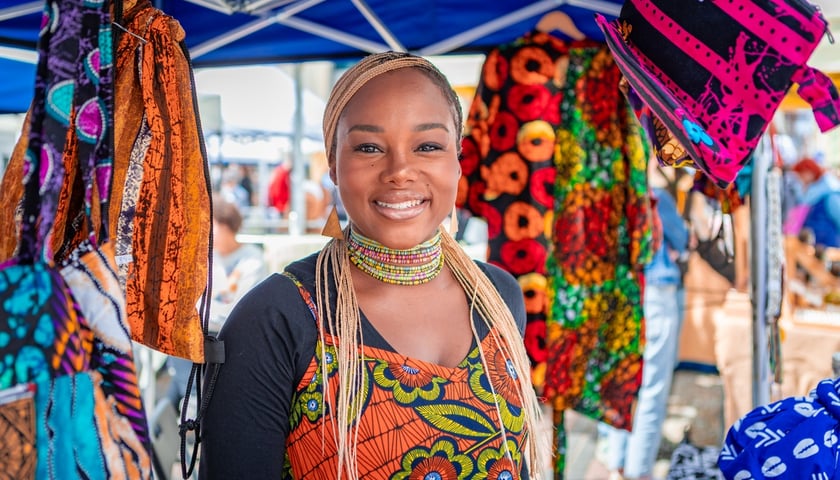 Powiększ obraz: <p>Targi rzeczy niepospolitych Artishop koło kościoła św. Marii Magdaleny. Na zdjęciu wystawczyni z barwnymi tekstyliami.</p>