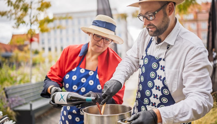 Powiększ obraz: <p>Kamila Kokot i Tomasz Sielicki pokazują, jak zrobić kapustę po wrocławsku. Zdjęcie wykonano 25 sierpnia 2025 na placu Nowy Targ, podczas kręcenia filmu.</p>