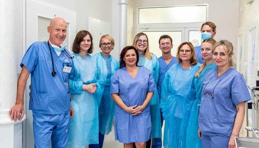 Grupa lekarzy w niebieskich kitlach. Zespół, który prowadził terapię CAR-T we wrocławskiej Klinice Hematologii UMW.