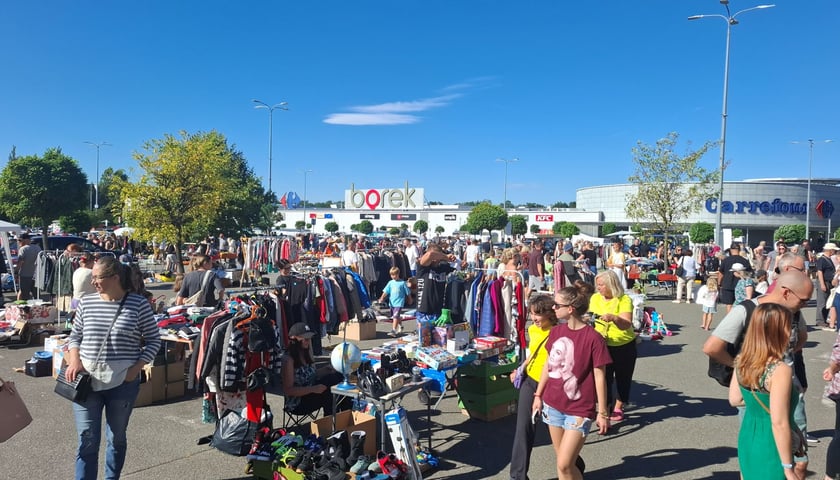 Powiększ obraz: <p>Na zdjęciu stoiska i ludzie spacerujący latem 2025 podczas Wrocławskiej Wyprzedaży Garażowej</p>