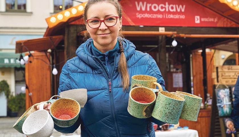 Powiększ obraz: Monika Sikorska pokazuje kubki, które własnoręcznie wykonała od początku do końca w swojej pracowni Monifaktura