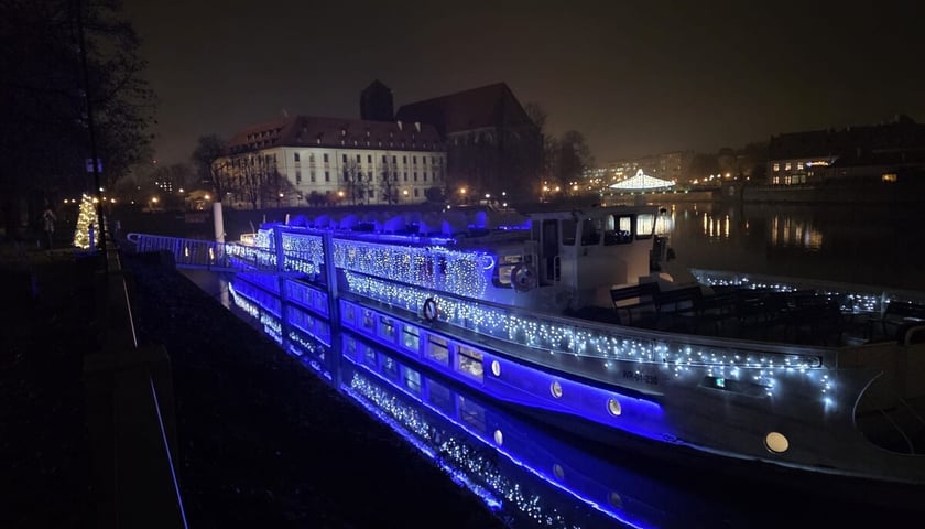 Powiększ obraz: <p>Oświetlony na niebiesko statek Wratislavia cumujący przy bulwarze Dunikowskiego we Wrocławiu</p>