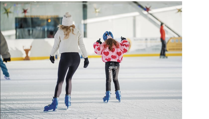 Powiększ obraz: Kobieta i dziewczynka ślizgające się na łyżwach na lodowisku przy ul. Jaksonowickiej