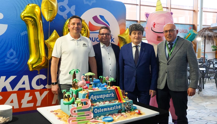 Powiększ obraz: Urodzinowy tort, od lewej: Paweł Rańda - wiceprezes Aquaparku Wrocław, Grzegorz Kaliszczak - prezes Aquaparku Wrocław, Ryszard Kessler - wiceprezydent Wrocławia, Artur Siewierski - wiceprezes Aquaparku Wrocław