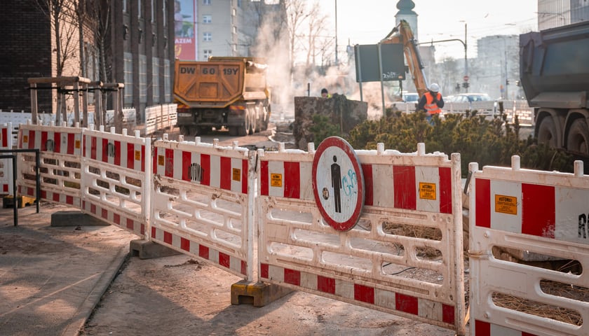 Powiększ obraz: Usuwanie awarii wodociągowej przy ul. Traugutta, 20.02.2026. Przejezdna ulica, ale ze zwężeniem. Zajęty chodnik.