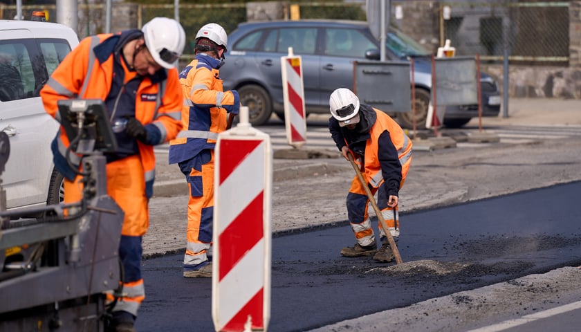 Powiększ obraz: Układanie masy bitumicznej na ulicy Powstańców Śląskich między Orlą a Krzycką