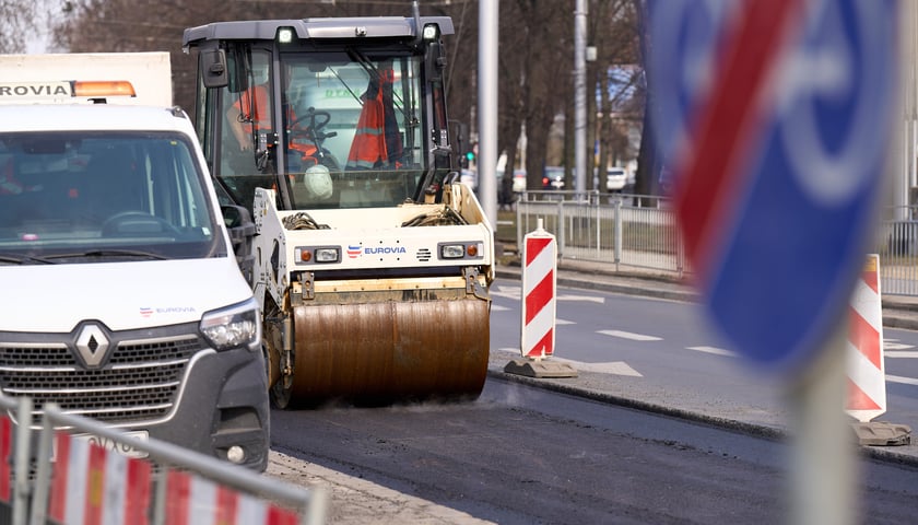 Powiększ obraz: Układanie masy bitumicznej na ulicy Powstańców Śląskich między Orlą a Krzycką