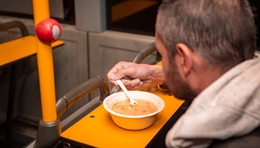 Powiększ obraz: <p>Mężczyzna jedzący zupę w Streetbusie</p>