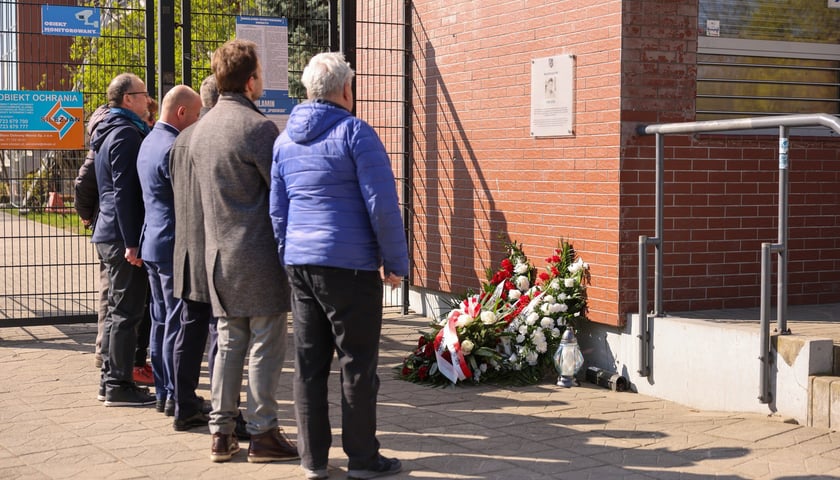 Składanie kwiat&oacute;w pod tablicą Jerzego Szmajdzińskiego