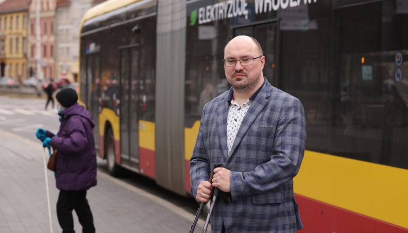 Michał Sałkowski, the deputy director of the Department of Transport of the Wroclaw City Office against the background of a public transport bus
