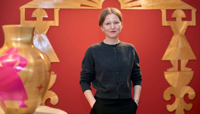 Na zdjęciu Ala Savashevich przed swoją pracą „Na głowach, na rękach, na nogach” 