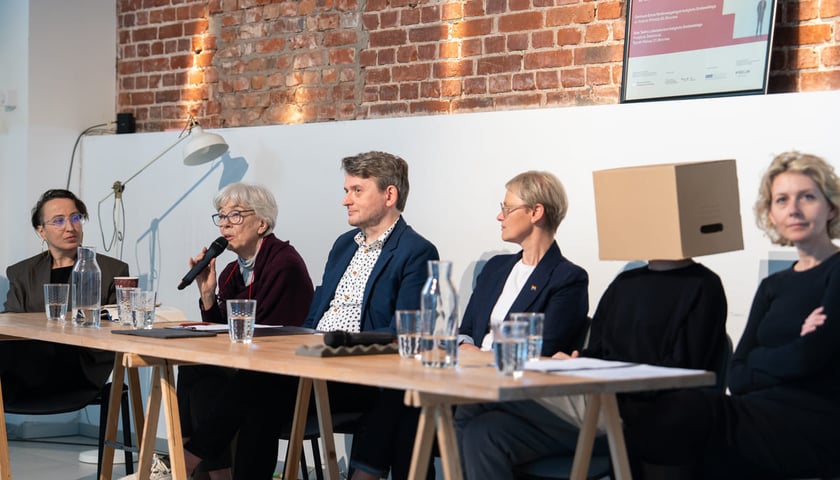 Konferencja prasowa Teatru na Faktach. Wrocław, 19.05.2026. Przy mikrofonie wrocławska aktorka Krystyna Krotoska. Z kartonem na głowie Tomasz Borczyk, autor spektaklu "7 pudełek" - zwycięzca poprzedniej edycji konkursu na dokomentalne czytanie performatywne. W pozostałych rolach (od lewej): Katarzyna Wiącek, Jakub Tabisz, Alina Szeptycka, Magdalena Mądra.