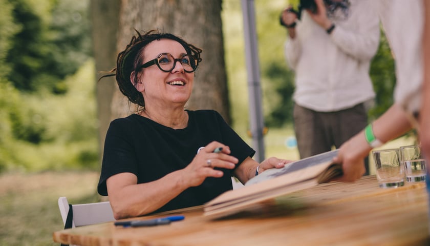 Olga Tokarczuk przy stole podpisuje książkę na poprzednim Festiwalu Góry Literatury (zdjęcie ilustracyjne)