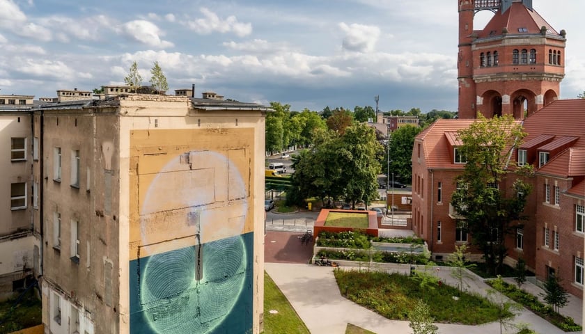 Na zdjęciu mural Łukasza Bergera na tle wieży ciśnień przy Wiśniowej