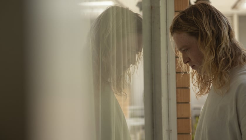 Na zdjęciu kadr z filmu „Nitram”, twarz mężczyzny odbijająca się w szybie 