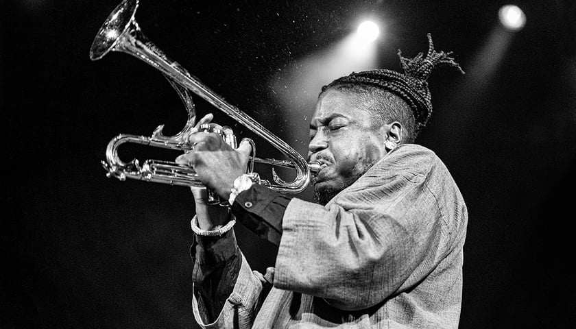 Na czarno-białym zdjęciu amerykański trębacz Christian Scott